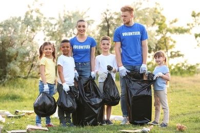 Photo of Volunteers with kids collecting trash in park