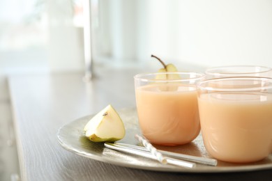 Photo of Tasty pear juice and cut fruit on wooden table, closeup