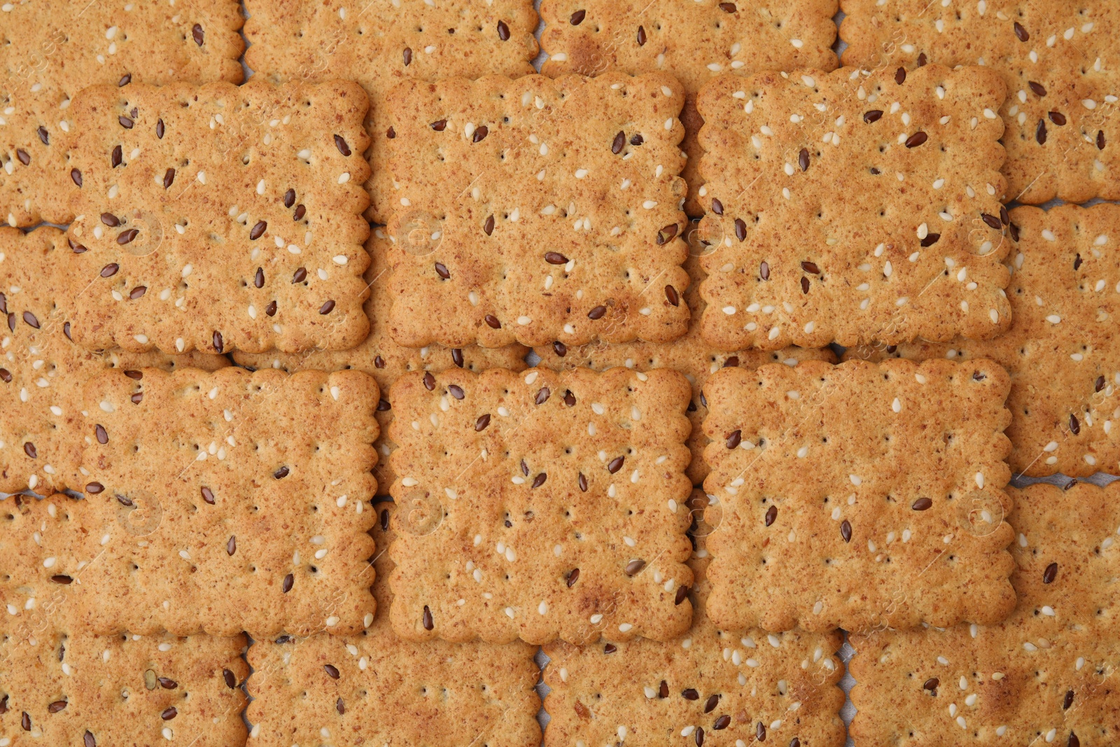 Photo of Cereal crackers with flax and sesame seeds as background, top view