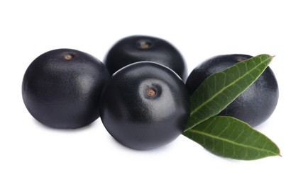 Photo of Pile of fresh ripe acai berries and green leaves on white background