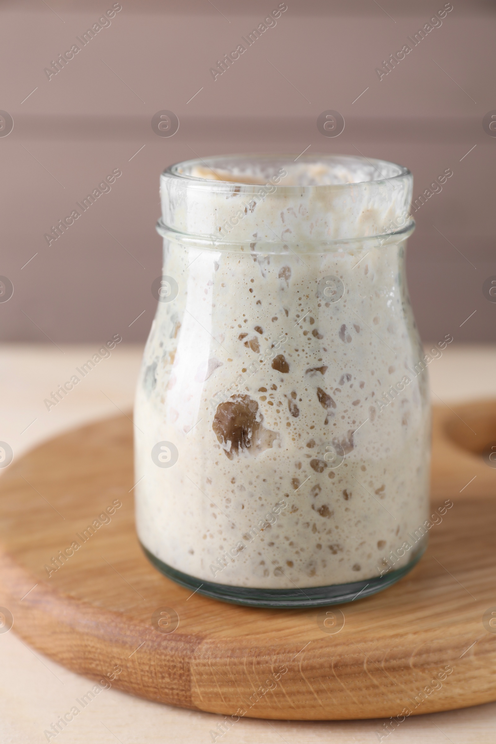 Photo of Sourdough starter in glass jar on table