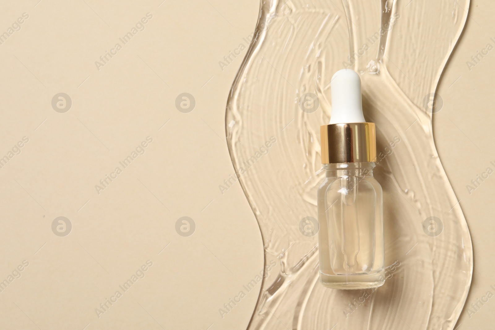 Photo of Bottle of cosmetic serum on beige background, top view. Space for text