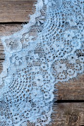 Photo of Beautiful lace on wooden table, top view