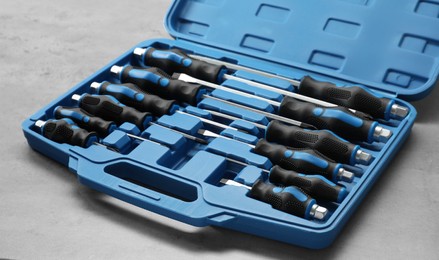 Photo of Set of screwdrivers in open toolbox on light table, closeup