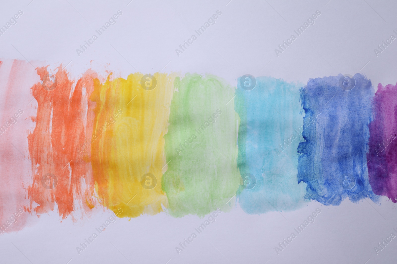 Photo of Rainbow drawing with watercolor paint on white paper, top view
