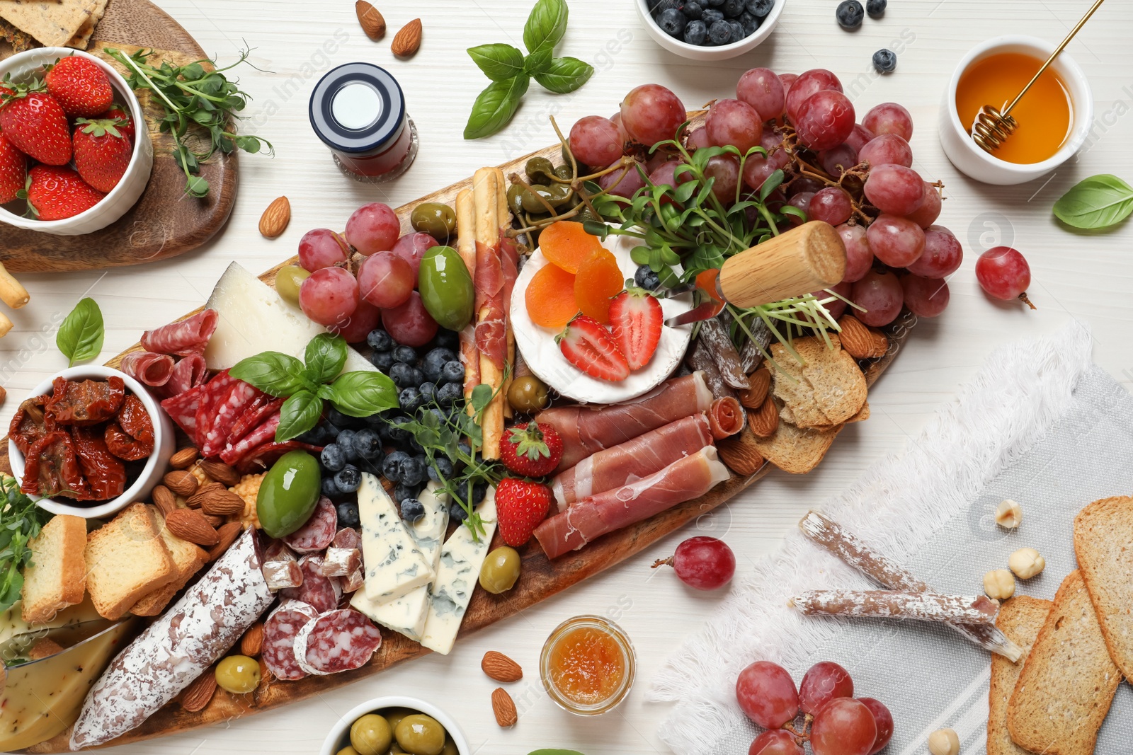 Photo of Set of different delicious appetizers served on white wooden table, flat lay