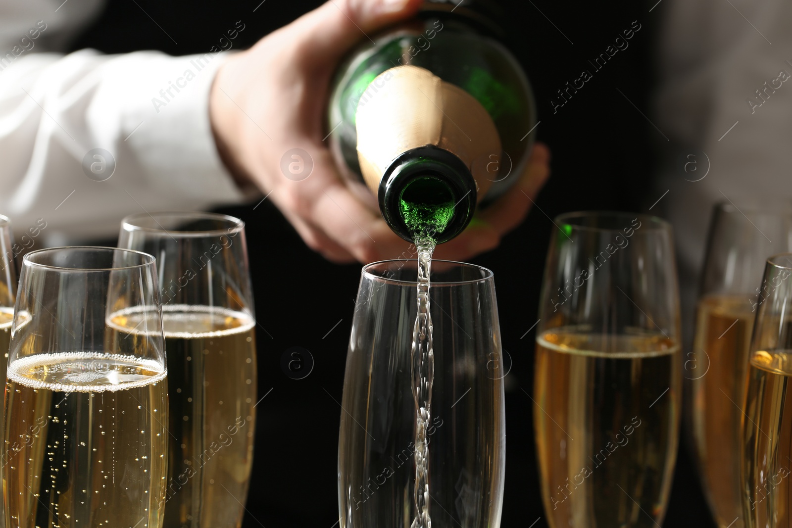 Photo of Waiter pouring champagne into glass, closeup view