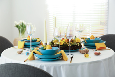 Photo of Festive Easter table setting with beautiful floral decor and eggs indoors