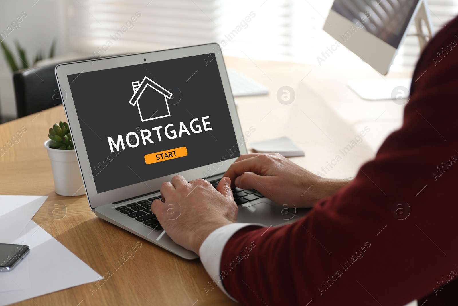 Image of Mortgage concept.  Man using modern laptop at table, closeup