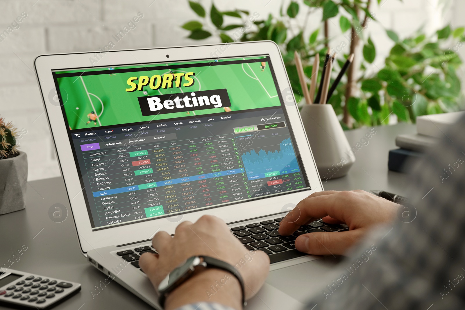 Image of Man betting on sports using laptop at table, closeup. Bookmaker website on screen