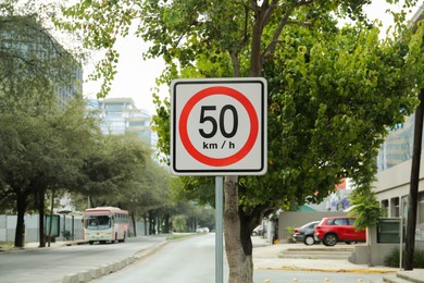 Photo of Post with road sign Maximum Speed 50 on city street