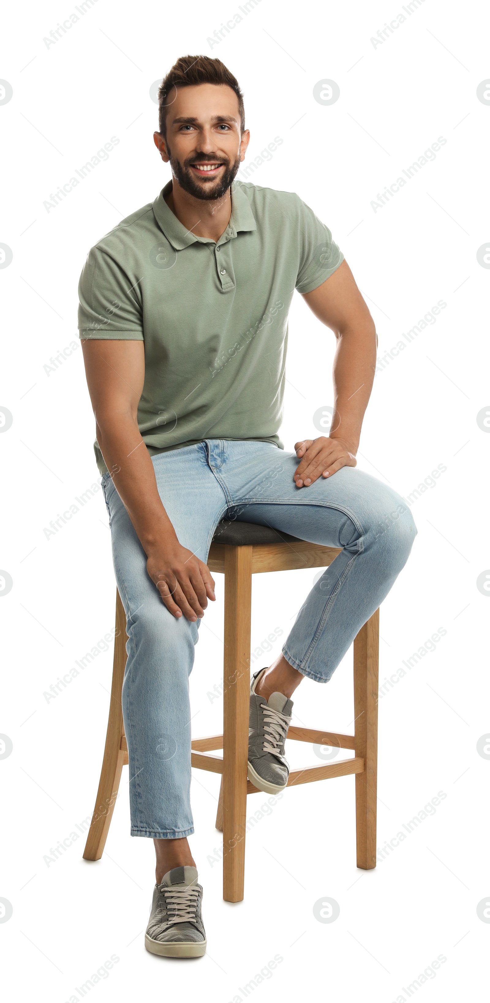 Photo of Handsome man sitting on stool against white background