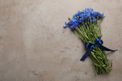 Bouquet of beautiful cornflowers on grey table, top view. Space for text