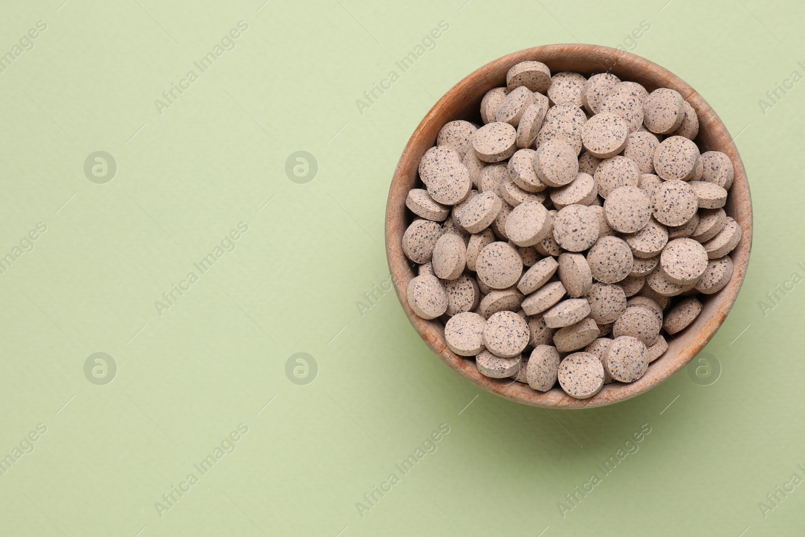 Photo of Beer yeast pills on light green background, top view. Space for text