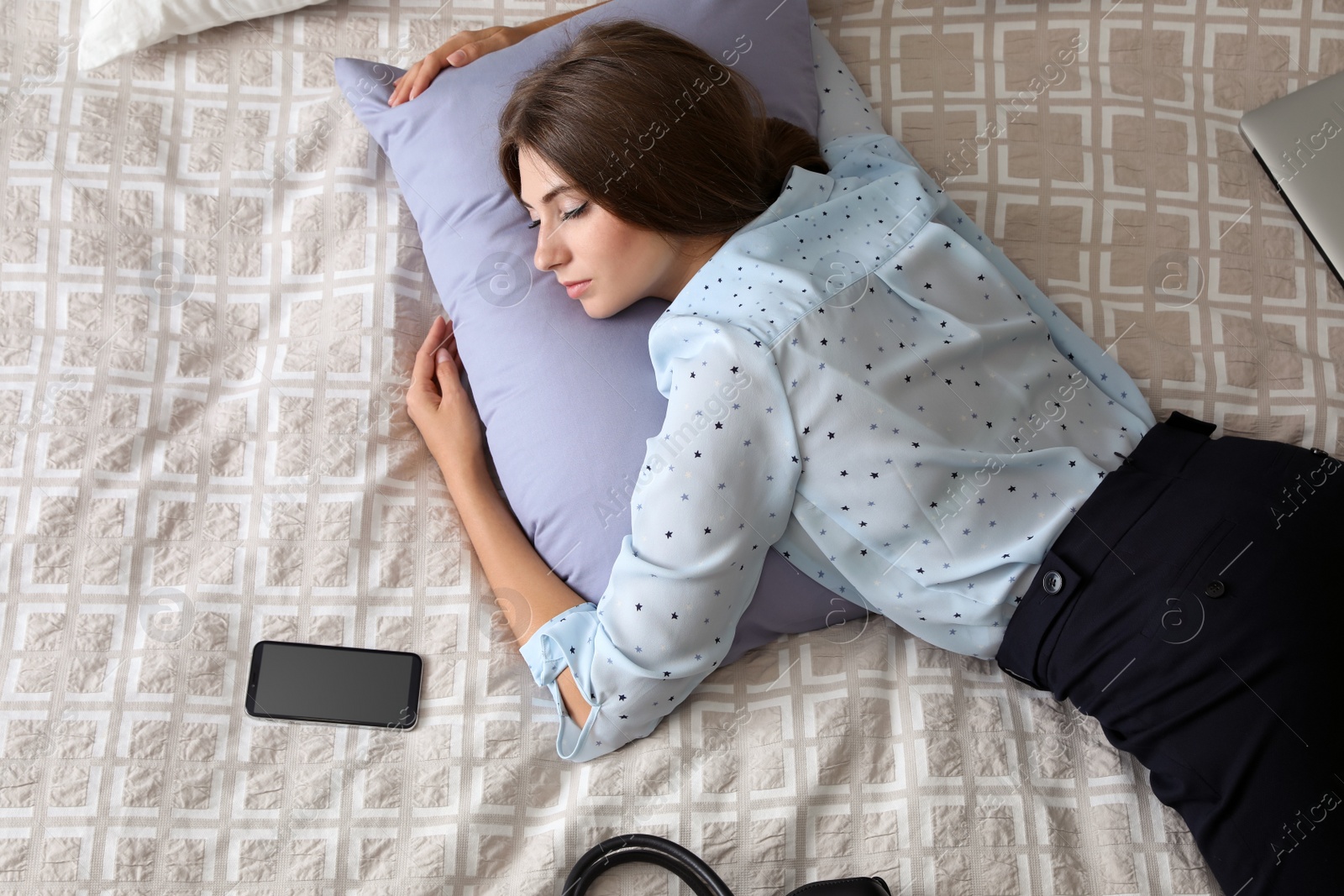 Photo of Exhausted businesswoman in office wear sleeping on bed at home after work, above view