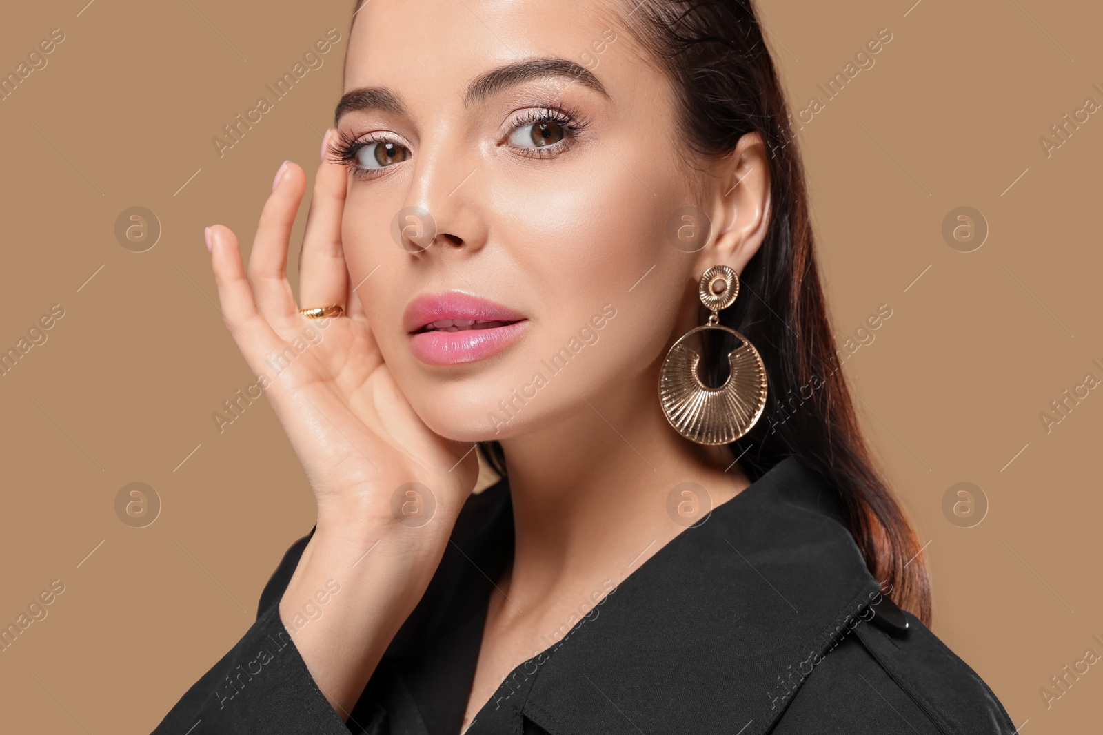 Photo of Portrait of young woman with beautiful makeup on light brown background, closeup