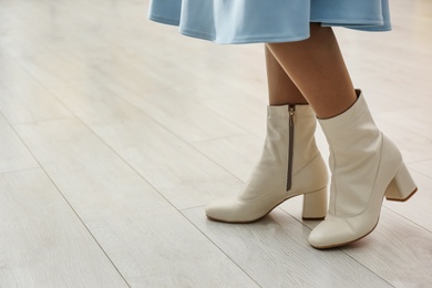 Photo of Woman wearing stylish leather shoes indoors, closeup. Space for text