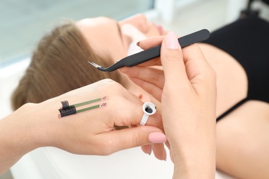 Beautician preparing for eyelash extensions procedure, closeup