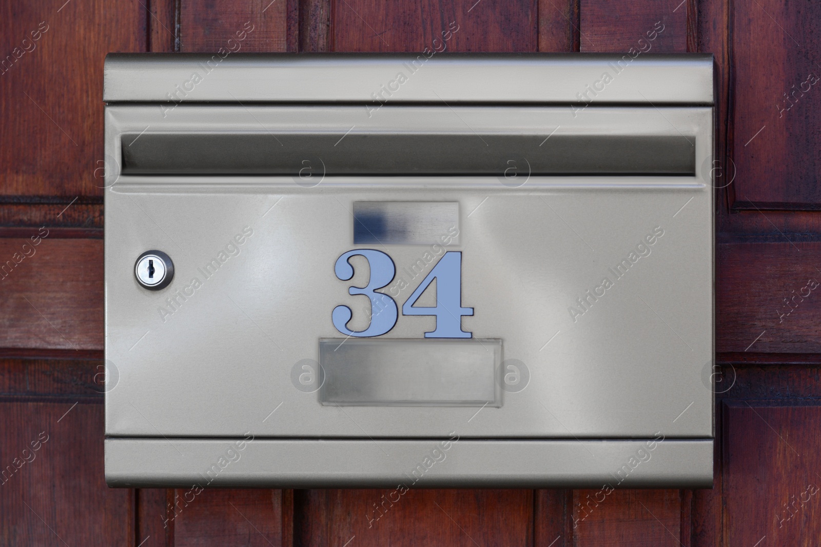 Photo of Metal letter box on wooden wall outdoors