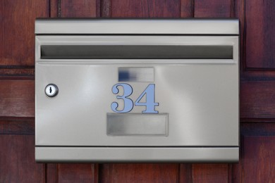 Photo of Metal letter box on wooden wall outdoors