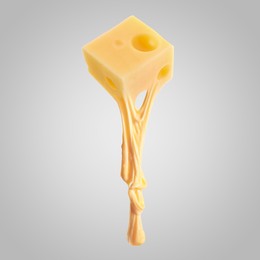 Image of Tasty cheese stretching in air on grey background