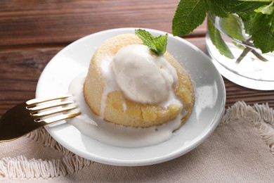 Photo of Delicious vanilla fondant served with ice cream on wooden table, closeup