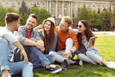 Photo of Happy people spending time together on green grass in park