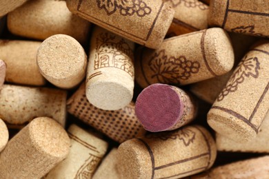 Photo of Many corks of wine bottles with grape images as background, top view
