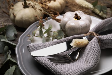 Photo of Festive table setting with autumn decor on wooden desk, closeup