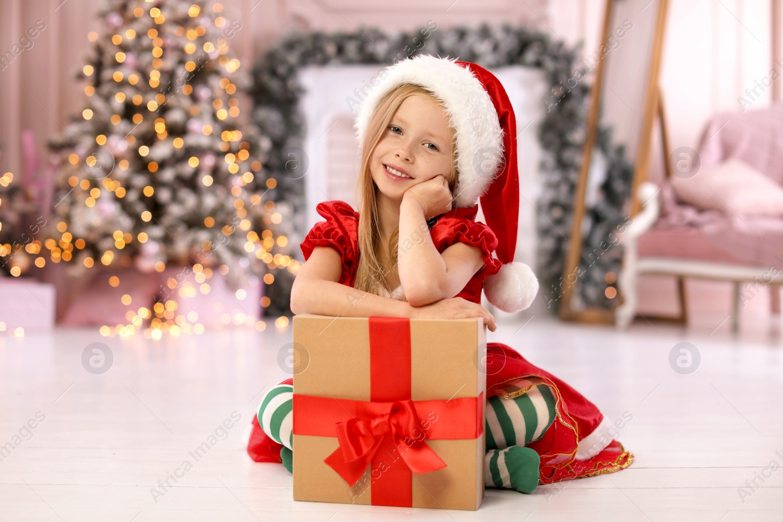 Photo of Cute little child with Christmas gift at home