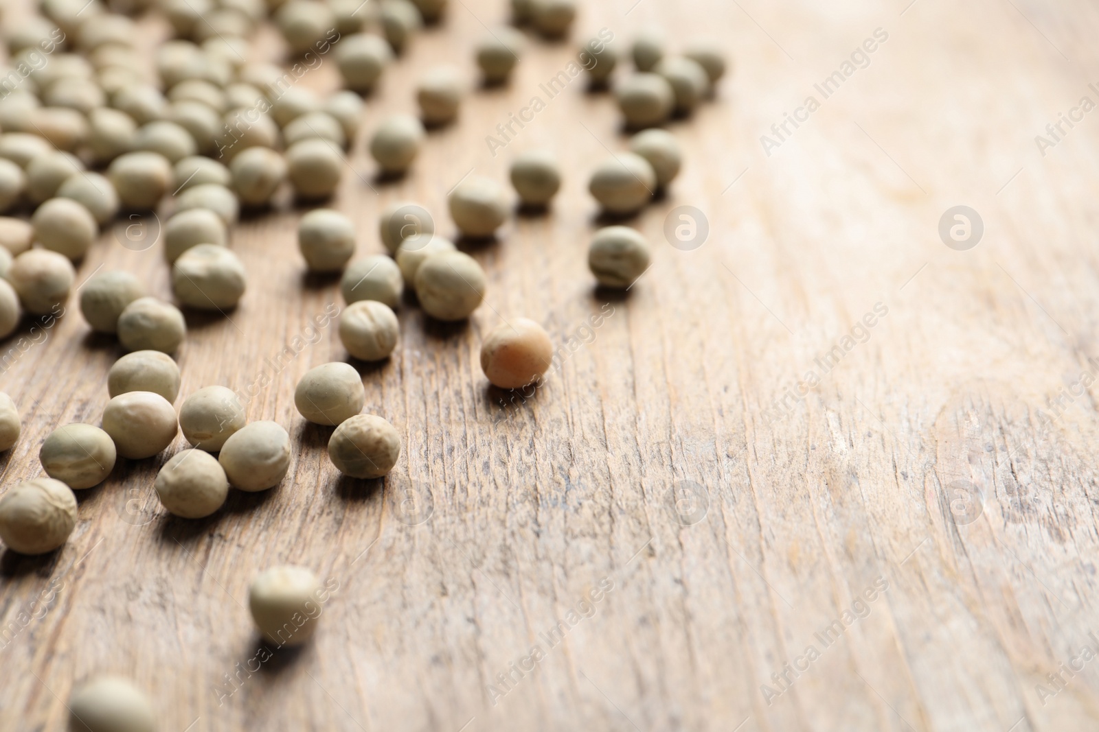 Photo of Raw dry peas on wooden background, closeup with space for text. Vegetable seeds