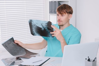 Photo of Doctor examining neck MRI images in clinic