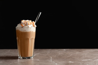 Photo of Glass with delicious caramel frappe on table