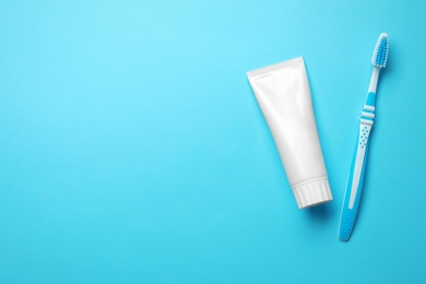 Photo of Blank tube of toothpaste and brush on color background, top view with space for text