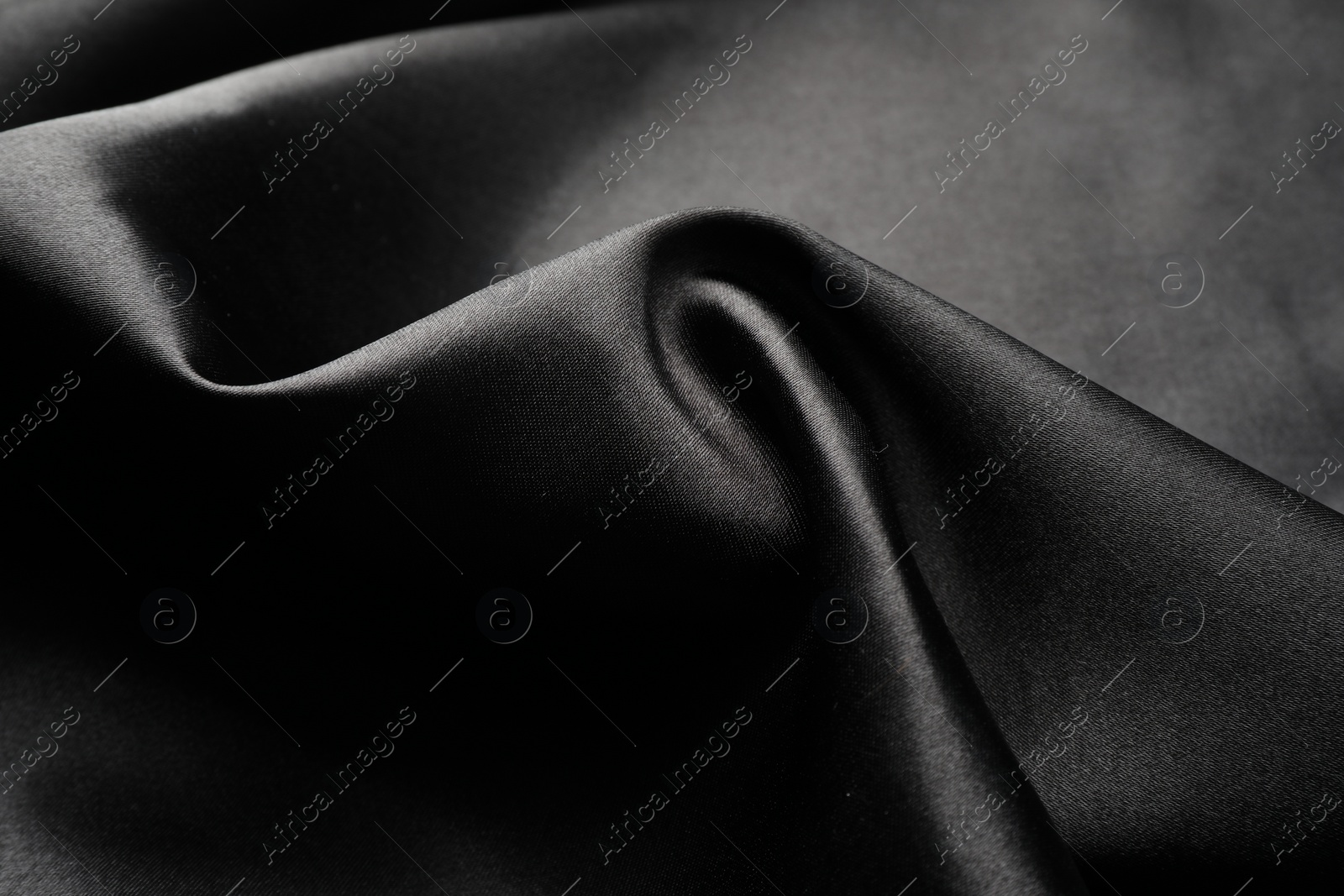 Photo of Crumpled black silk fabric as background, closeup