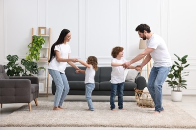 Photo of Happy family dancing and having fun in living room