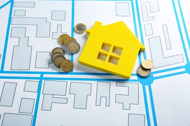 Photo of Coins and yellow house model on cadastral map
