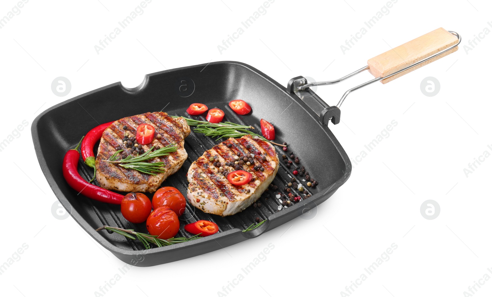 Photo of Grill pan with delicious pork steaks, spices and vegetables isolated on white