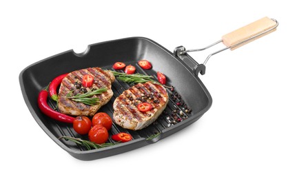 Photo of Grill pan with delicious pork steaks, spices and vegetables isolated on white