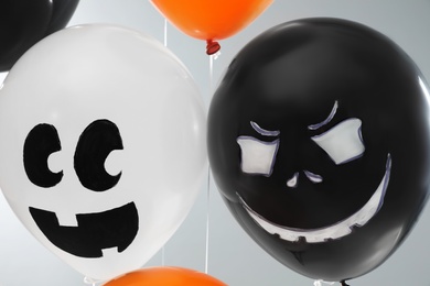 Photo of Spooky balloons for Halloween party on light grey background