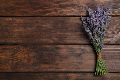 Beautiful lavender bouquet on wooden background, top view. Space for text