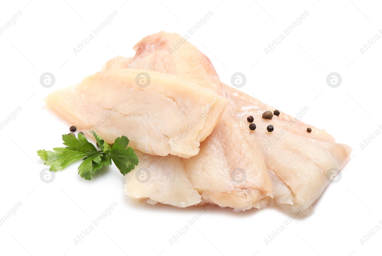 Photo of Pieces of raw cod fish, parsley and peppercorns isolated on white