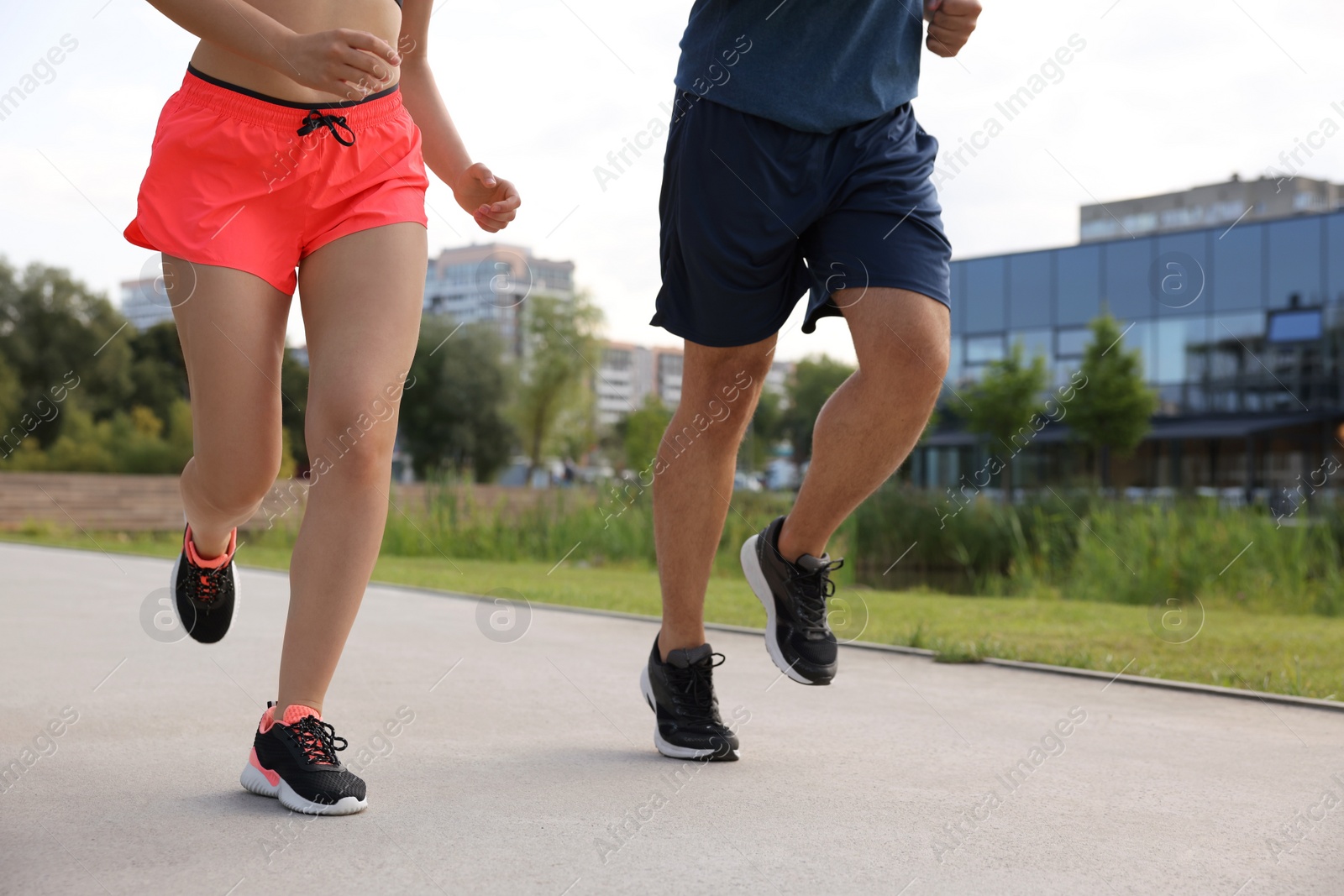 Photo of Healthy lifestyle. Couple running outdoors, closeup view