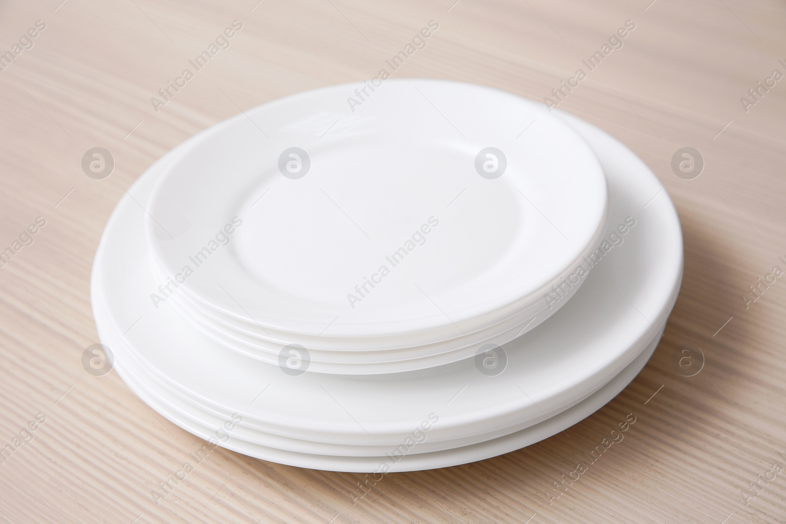 Photo of Stack of clean dishes on wooden table