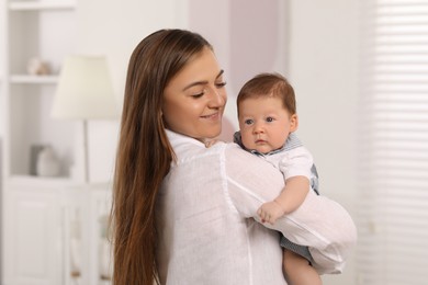 Mother holding her cute newborn baby at home