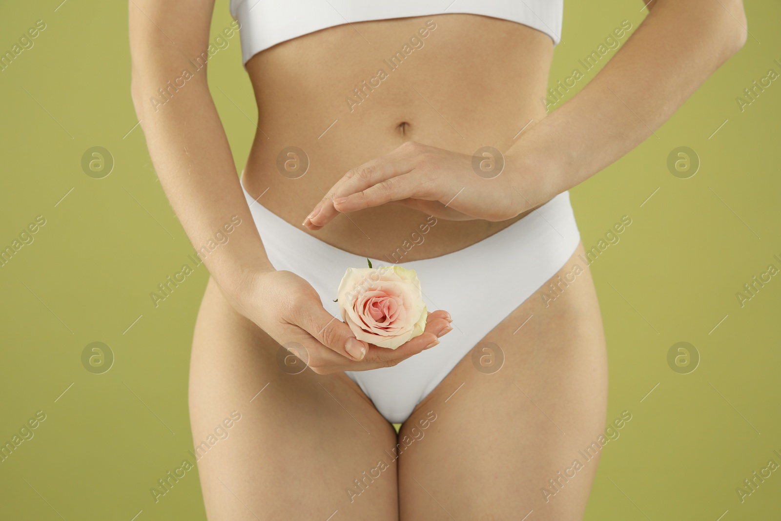 Photo of Gynecology. Woman in underwear with rose flower on green background, closeup