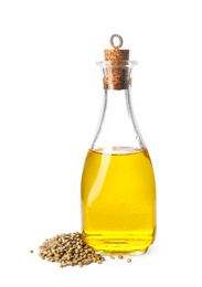 Bottle with hemp oil and seeds on white background