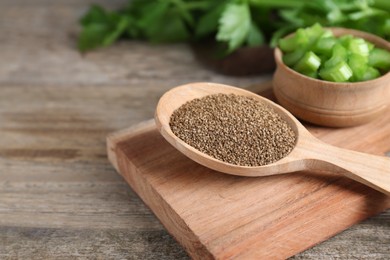 Photo of Spoon of celery seeds on wooden table, closeup. Space for text