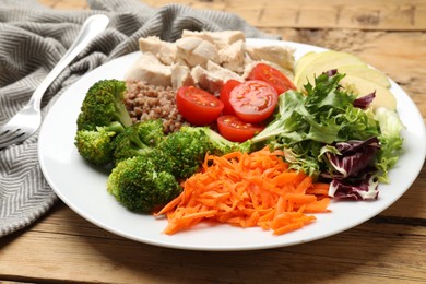 Photo of Balanced diet and healthy foods. Plate with different delicious products on wooden table, closeup