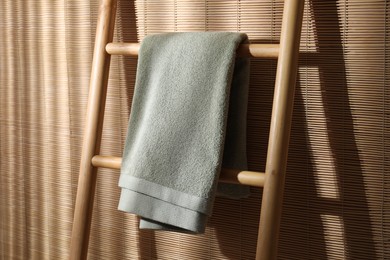 Green terry towel on wooden ladder indoors